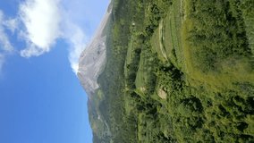 Vertical video. Aerial view of picturesque farmland on the slopes of the active Merapi volcano, Indonesia - Powered by Shutterstock - Get 15% off with code: PIKWIZARD15