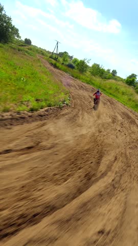 FPV shot of a racer on a motocross bike on a track at high speed in slow motion. Concepts of extreme sports, adrenaline, and racing