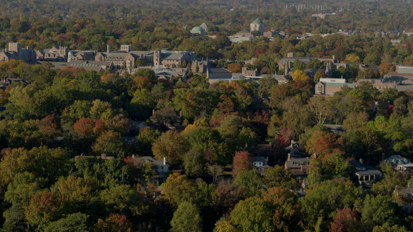 Beautiful aerial of Clayton neighborhood in St. Louis, Missouri, in autumn with Washington University on the horizon. Captures vibrant fall foliage, charming homes, and a serene, colorful landscape.