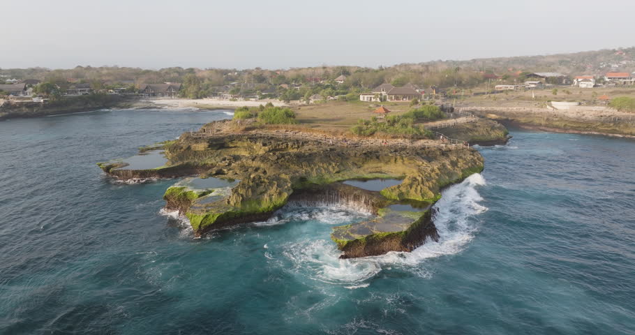 Aerial static overview of waves crashing at Devil's Tears, Nusa Lembongan, with dramatic ocean scenery