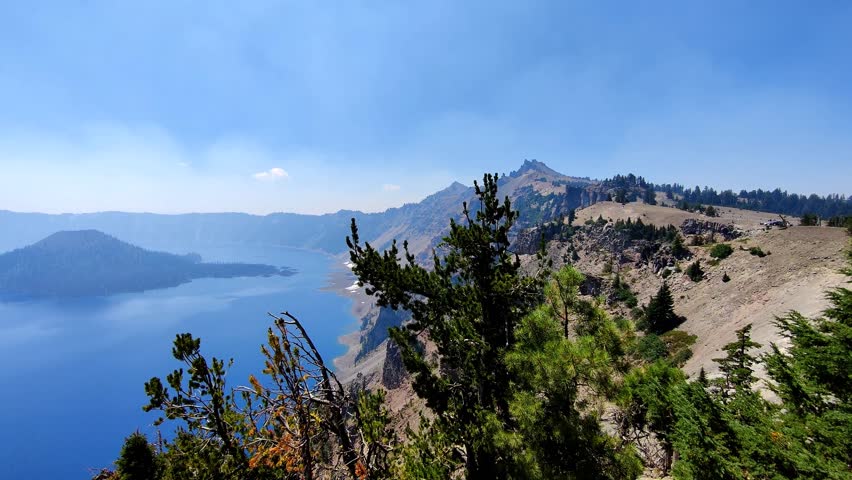 Wide Angle Pan Across Crater Lake Covered in Light Smoke