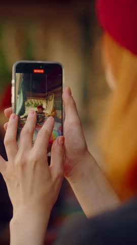 Take mobile photo using modern smartphone, closeup view of screen with image of male tourist in motorhome. Young adult woman holding mobile phone and photographing her friend, travel blogger, review