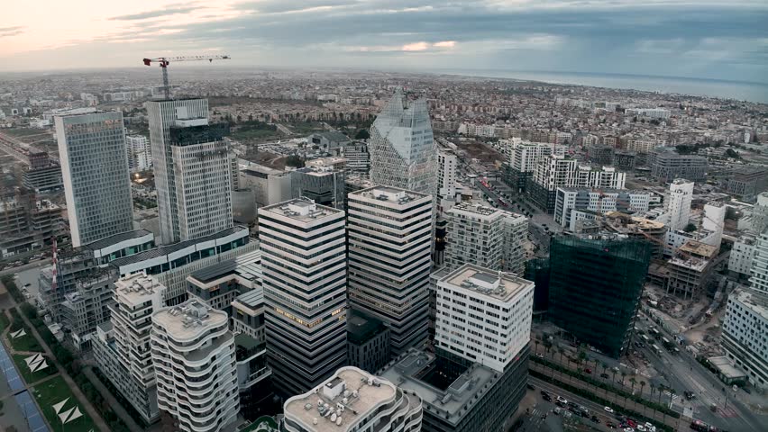 Twilight drone view of CFC with completed skyscrapers and active construction. This 4K footage highlights Morocco’s urban growth and Africa’s economic progress.
