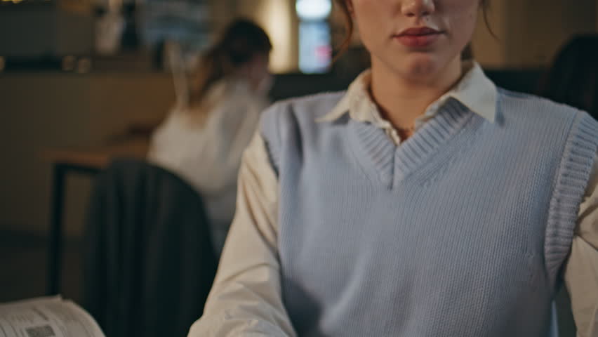 Closeup secretary doing paperwork at late coworking. Unrecognizable busy lady staple documents working at evening open space. Office lady hands holding papers sorting financial reports at cabinet