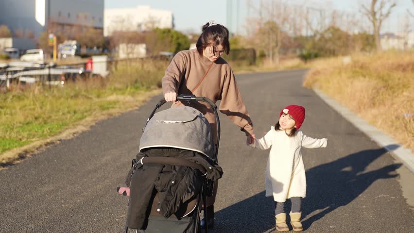 In December 2024, a Japanese parent and child, a 3-year-old girl and her mother in her 30s, spend time in a lush park in Higashi Ward, Fukuoka City, Fukuoka Prefecture.
