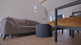 Modern minimalist living room interior featuring a beige sofa, black round coffee table, and mustard-yellow cushion, highlighted by natural lighting and wooden flooring. Contemporary home decor - Powered by Shutterstock - Get 15% off with code: PIKWIZARD15