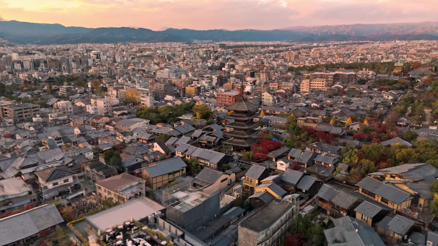 A breathtaking drone clip capturing the iconic Fushimi Inari Shrine in Kyoto at sunset, surrounded by vibrant autumn foliage.