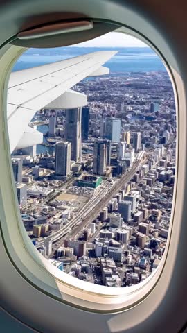 panoramic view of the port and city of Yokohama in Japan. Panoramic aerial view of the city of Yokohama, Japan, seen through the window of an airplane. Vertical and portrait format