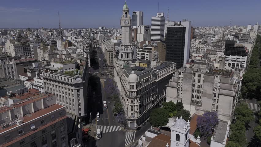 Drone flies from Plaza de Mayo toward city legislature building with clock tower in Buenos Aires, Argentina