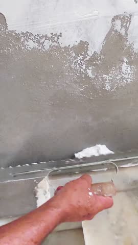 Worker applying spackle to wall