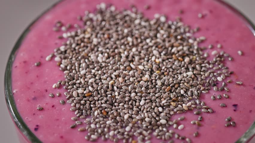 close up of fresh pink raspberry smoothie decorated with chia seeds for healthy breakfast turning around, zoom out