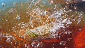 Lime slices splashing into iced tea, creating bubbles and ripples in slow motion 300fps - Powered by Shutterstock - Get 15% off with code: PIKWIZARD15