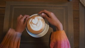 POV shot of girl hands drink coffee. Close up shot of girl holding Cappuccino on wooden table. Morning breakfast and coffee background.
 - Powered by Shutterstock - Get 15% off with code: PIKWIZARD15
