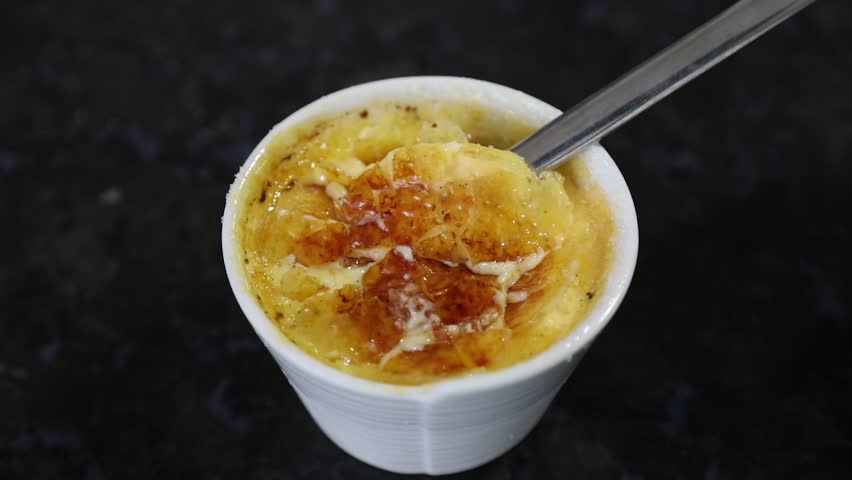 Crème brûlée, creme brule. Classic creme brulé being flambé. Burning, flaming, ramekins, vanilla beans, blowtorch, sugar