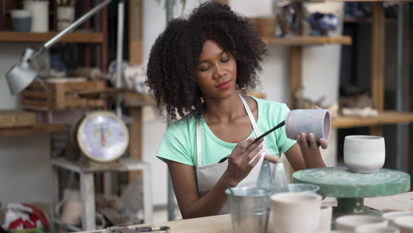 Young women is making earthenware at workshop. Small business and hand craft product.