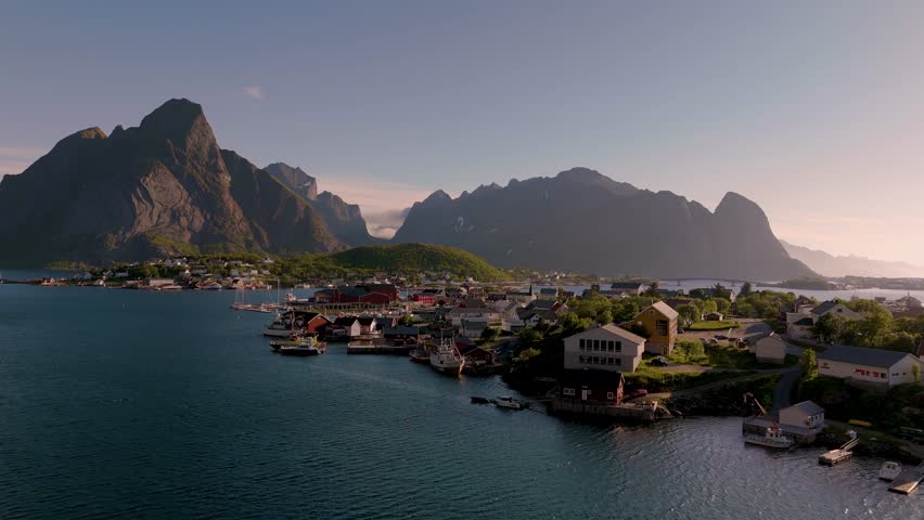 Experience the breathtaking beauty of Norways coastline as majestic mountains rise above tranquil waters. Enjoy the peaceful ambiance and vibrant colors, Reine village Lofoten Norway