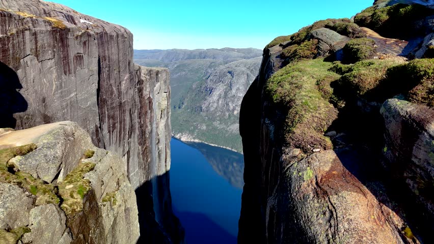 Norway majestic landscape featuring towering cliffs and unique rock formations. Experience the serene beauty and wonder of nature artistry in this remarkable location. Kjeragbolten Lysefjorden