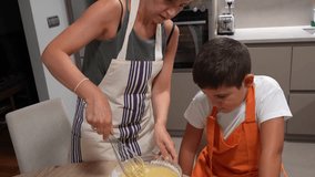 Mom and son whisking ingredients in a bowl, learning to bake a sponge cake together in their home kitchen - Powered by Shutterstock - Get 15% off with code: PIKWIZARD15