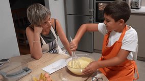 Child whisking batter in a glass bowl, learning to bake a sponge cake with his mother in their home kitchen - Powered by Shutterstock - Get 15% off with code: PIKWIZARD15