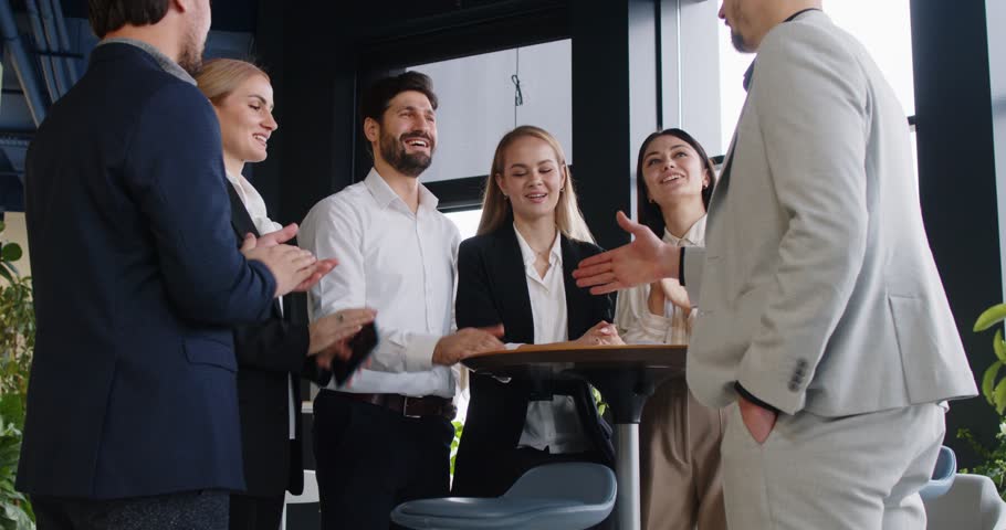 Business people team applauding and exchanges handshakes during a meeting in an office, celebrating a successful presentation and fostering collaboration and professional relationships.