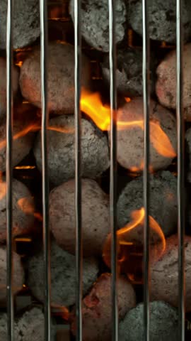 Super slow motion of burning charcoal on grill grid. Filmed on high speed cinema camera, 1000 fps. Top view. Vertical Aspect Ratio.