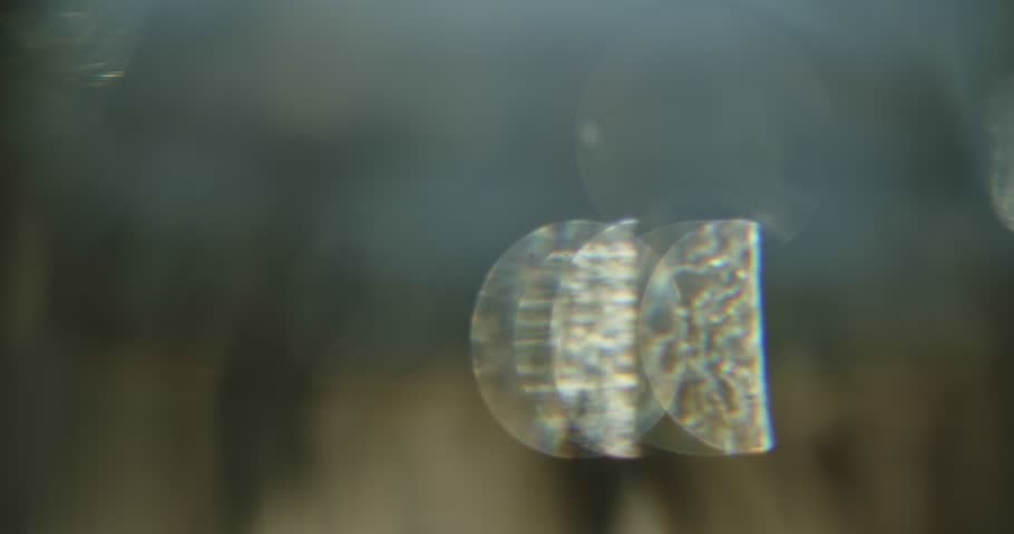 Bokeh Effect of Sunlight passing through a Glass filled with Water using a 50 mm lens with a wide aperture and shallow depth of field.  Overlay Film Effect.