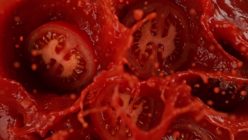Super Slow Motion Shot of Tomato Cuts Falling and Splashing into Sauce at 1000fps.