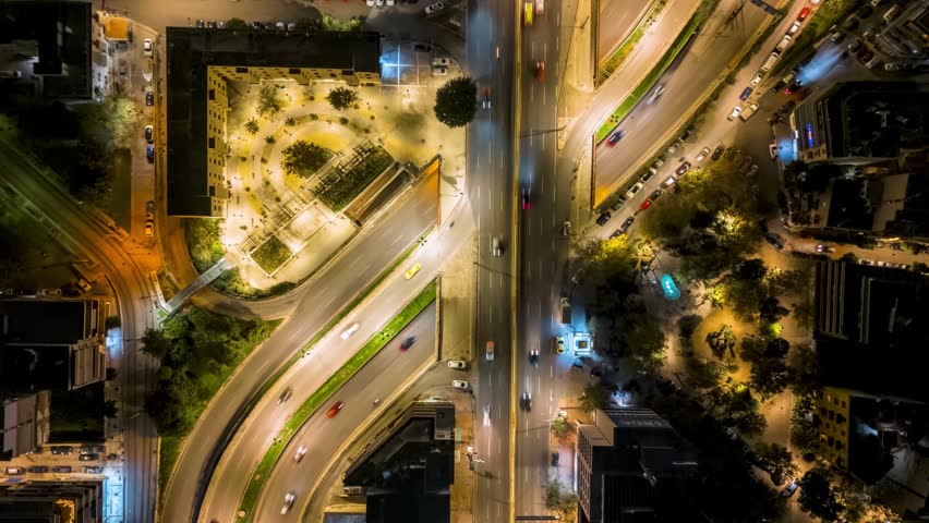 Hyper lapse top down view of a illuminated city street with car traffic and houses during night, Athens, Greece