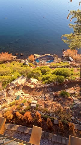 footage of a gorgeous winter landscape at Lake Tahoe with blue lake water, lush green trees and plants and snow capped mountains in Crystal Bay Nevada USA