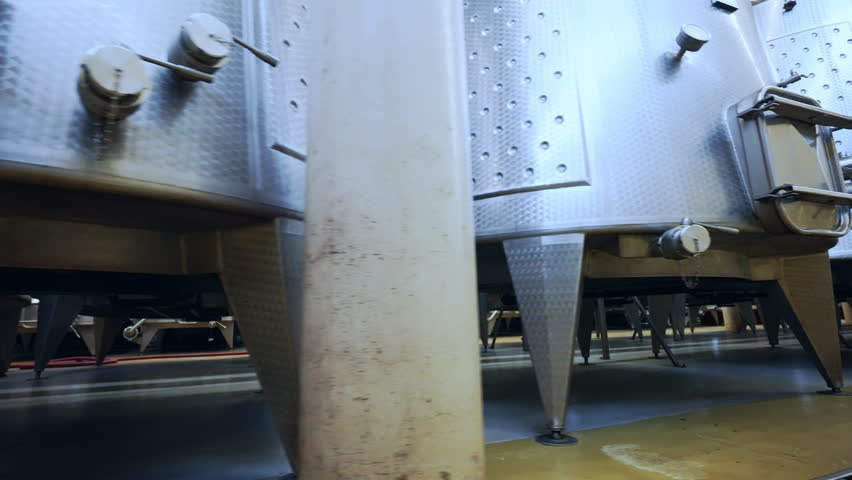 Winemaking factory with large stainless tanks for different processes, high quality wine production in specialised facility, metal barrels for wine storage, viticulture concept. High quality 4k