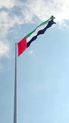 UAE flag waving in the blue sky, national symbol of UAE. High quality 4k footage.