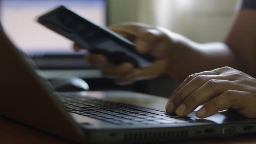 Cyber security 2FA protection concept. Businessman working on a laptop to login password two-step authentication, verification code on smartphone screen for identity identification for online banking.