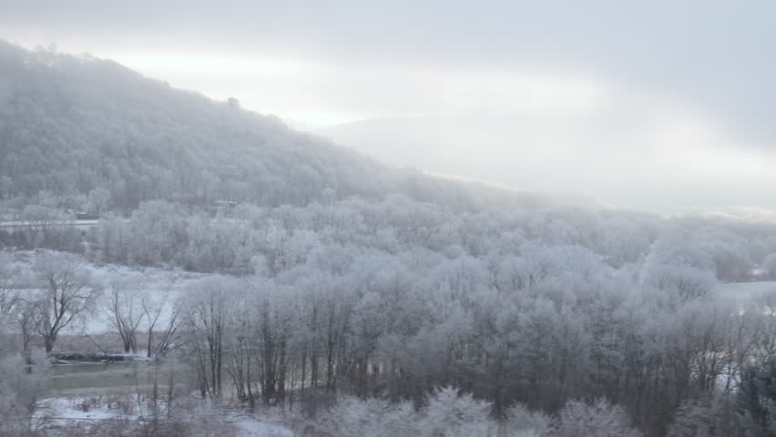 Aerial view of snowy hillsides in New York State. Shot on a winter morning in 4k.