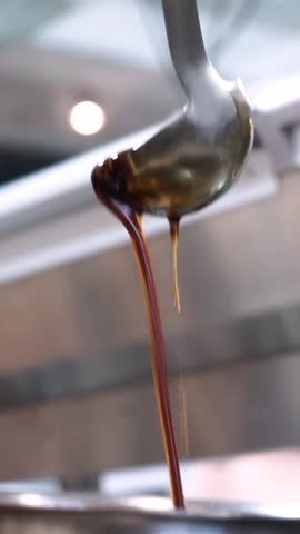 Pouring soy sauce into the pot, adding flavor to the dish.