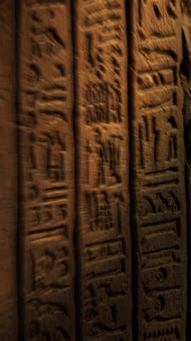 Light spot moving on ancient egypt hieroglyphics carving on wall of temple. Vertical video