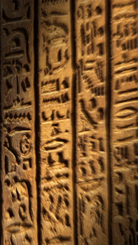 Light spot moving on ancient egypt hieroglyphics carving on wall of temple. Vertical video