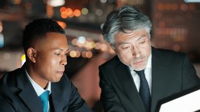 Multinational business people having a meeting while looking at a screen with the city night view in the background - Powered by Shutterstock - Get 15% off with code: PIKWIZARD15