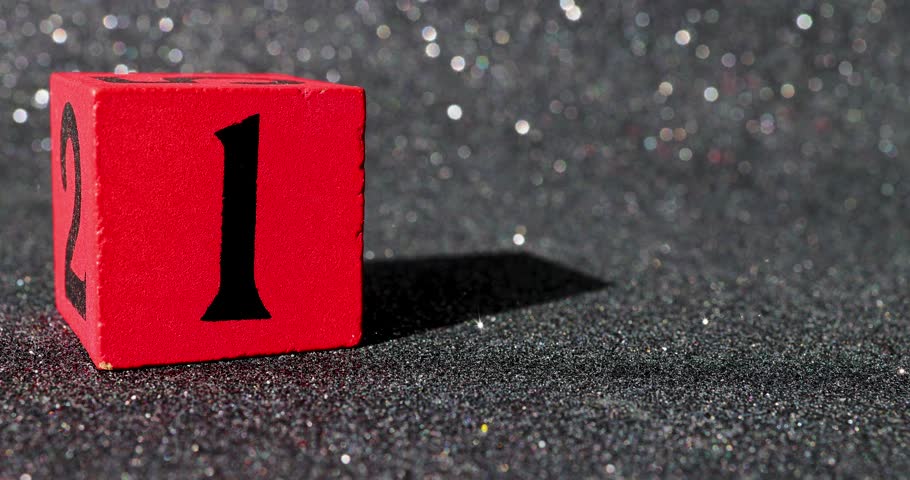 Footage of a red block with a black glittery background showing the number 1 on a block being put down and taken back up again