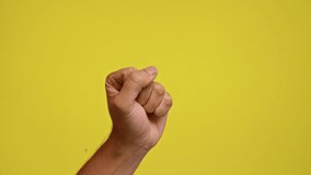 Male hand raised against a bright yellow background demonstrating an open palm gesture of requesting or signaling while capturing skin details closely - Powered by Shutterstock - Get 15% off with code: PIKWIZARD15