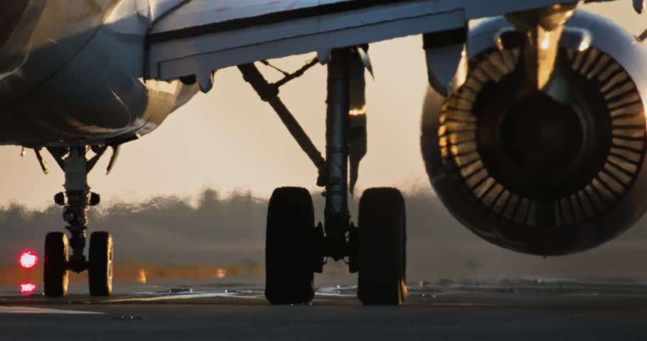 Close-up of airplane wheels and turbines before takeoff at sunset. A passenger plane is preparing for takeoff. High quality 4k footage