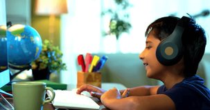 Studious Indian Asian Boy Attending Online Class at Home Using Computer, Learning Virtually and Communicating with Teacher, Highlighting Modern Education, E-Learning, and Technology in Daily Life - Powered by Shutterstock - Get 15% off with code: PIKWIZARD15