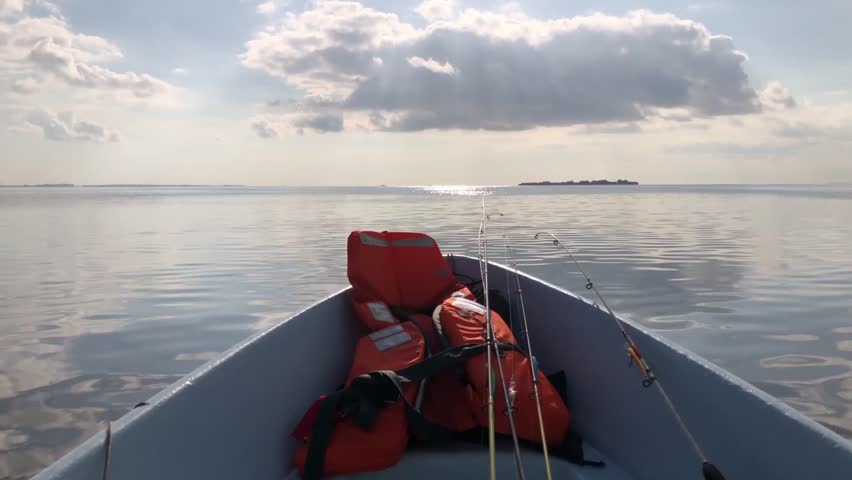 sea view from fishing boat, life jacket and fishing rods in foreground, travel theme
