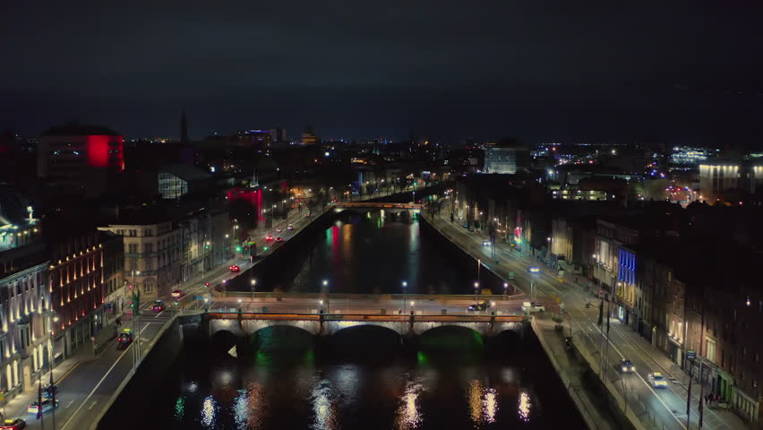 Aerial pullback of Dublin at night, showcasing the cityscape in the late hours