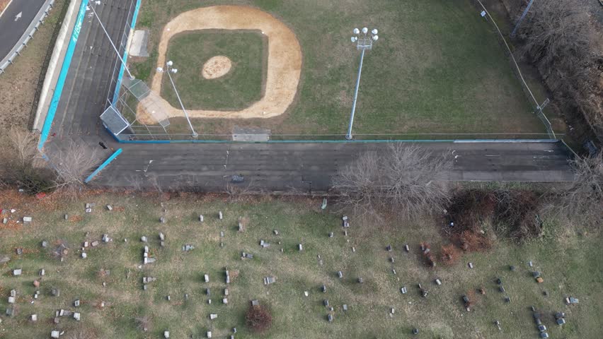 A panoramic view of  Jersey city a New york city  across a body of water.  In the foreground, a highway and industrial area are visible. The sky is partly cloudy, offering a balanced contrast. 