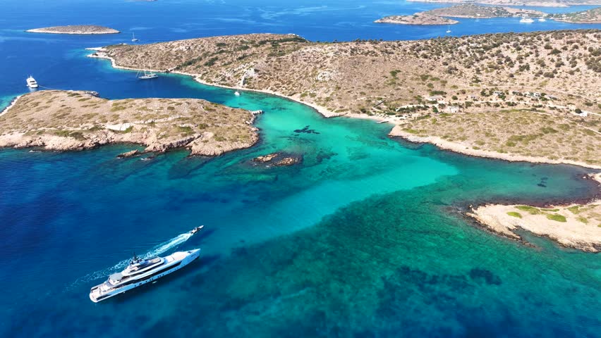 Aerial drone cinematic video of tropical paradise exotic island bay with emerald crystal clear beach resembling a blue lagoon visited by luxury yachts and sail boats in Caribbean destination