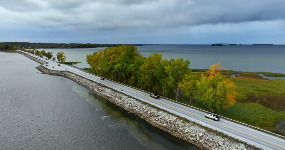 Highway crosses the waterscape of Lake Champlain in Vermont, New England, USA. Overcast sky is above the scenery. Aerial view.