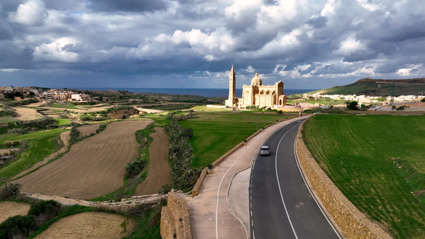 Aerial view of Stunning view of a illuminated Basilica of Our Lady of Ta' Pinu on a hilltop with dramatic sky and landscape. Gozo. Malta