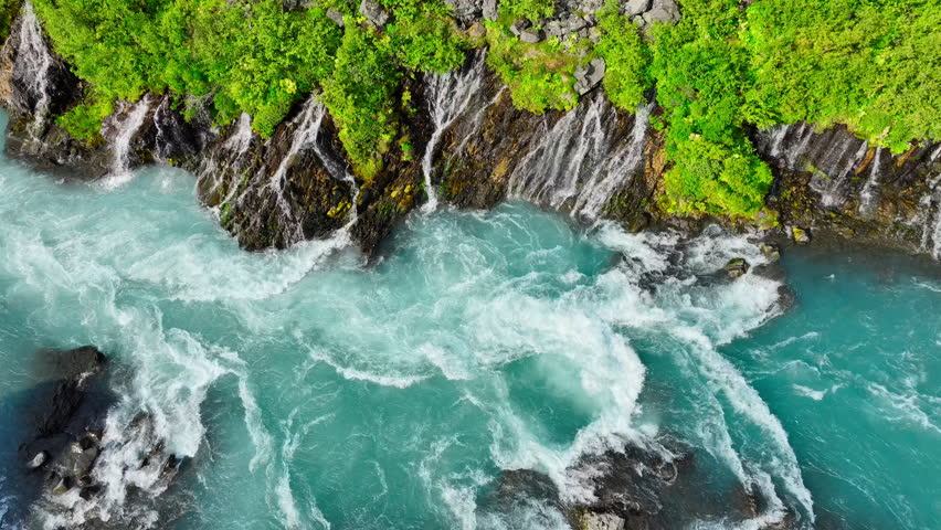 Summer waterfall, Many small streams flow from the lava field. River with the purest glacial water of turquoise blue color. Pure nature, drinking water. Epic landscape aerial view 4k. Iceland.