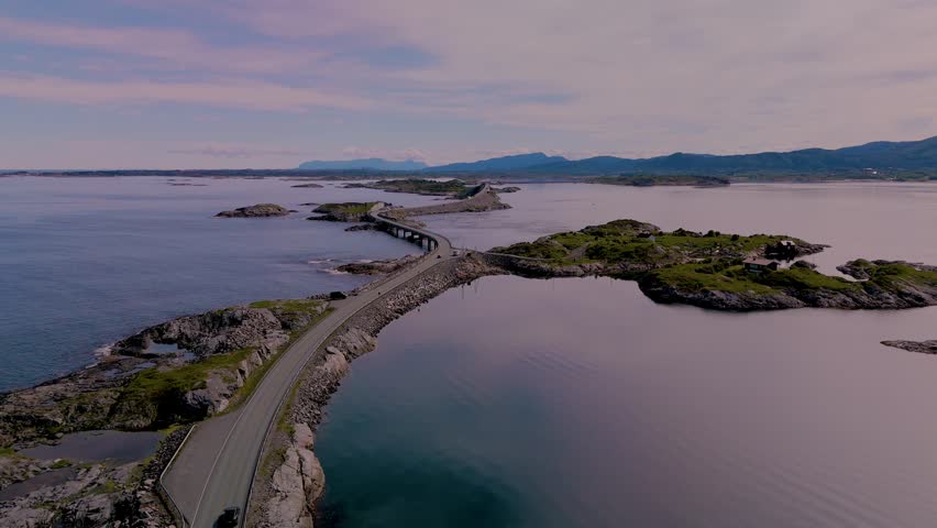 Discover the breathtaking views of Norways coastline as a car navigates the winding roads connecting picturesque islands. Atlantic Ocean Road (Atlanterhavsveien) in Norway