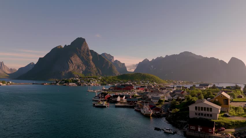 Experience the breathtaking beauty of Norway rugged mountains and serene fjords. Explore the vibrant coastal villages nestled against dramatic landscapes during golden hour. Reine village Lofoten